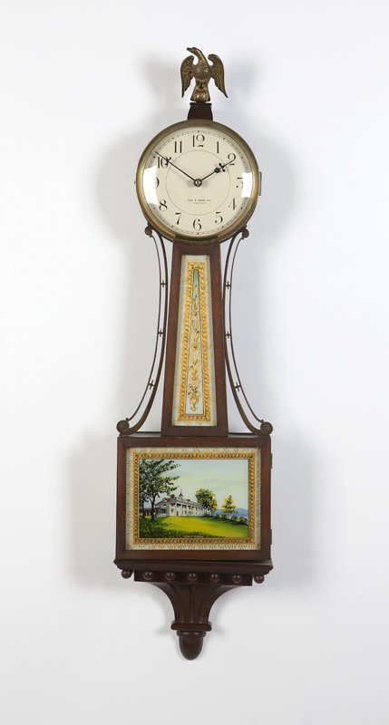 A Waltham for Theodore B. Starr banjo clock: Circa 1900, marked to dial ''Theo B. Starr Inc. / Waltham'', the cream enameled tin dial with black Roman numerals and minute divisions, within a brass bezel under a glazed hinged brass door, single-w
