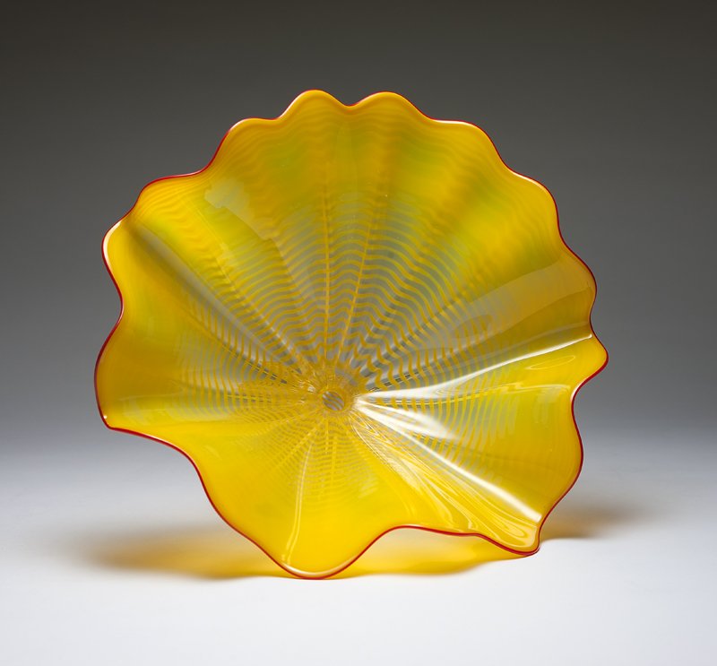 A Dale Chihuly yellow glass 'Seaform' vase: Late 20th century, etched signature ''Chihuly'' (Dale Chihuly, b. 1941, Tacoma, WA), the wide undulating rim with red lip wrap, tapering to a tightly gathered neck over a ribbed, spherical body, toget