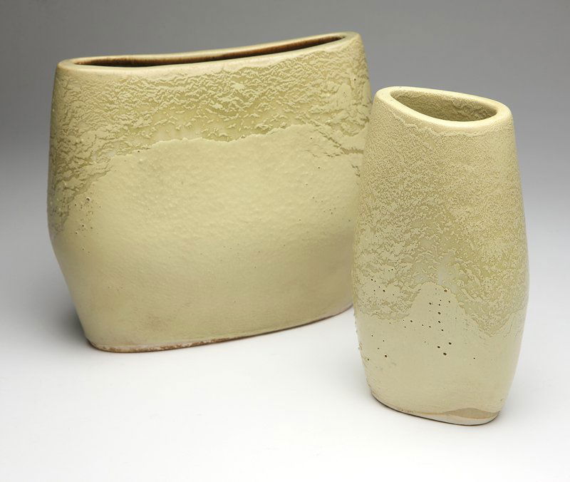 Two Russel Wright for Bauer vases: Circa 1940's, the larger pillow vase stamped ''Russel Wright / Bauer'' (8.5'' H x 9.75'' W x 3.75'' D), the smaller corsage vase unmarked (8.25'' H x 4.5'' W x 3'' D), each with chartreuse lava glaze,