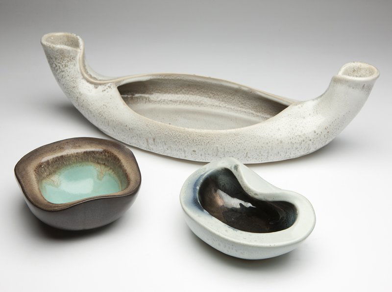 Three Russel Wright for Bauer ceramic articles: Circa 1940's, comprising: a centerpiece, unsigned, of boat shape with folded lips, the pointed ends upswept to form candle holders (5'' H x 18'' W x 7'' D); a square dish, signed ''Russel Wright / Bau
