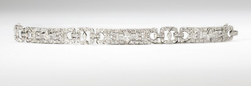 An Art Deco diamond and platinum bracelet: Platinum sectional links set with 6 marquise shape diamonds with 12 baguette and 174 single-cut diamond surround totaling approximately 5.50 cts, graded H-I-J color and SI clarity, 7.25'', est:$6000/8