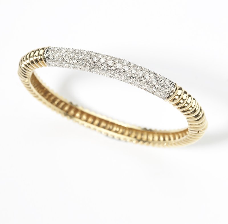 A gold and diamond fluted bangle: 18K white and yellow gold, topped with 85 full-cut round diamonds totaling approximately 2.60 cts, graded G-H color and VS clarity, 27.7 gms, 6.5'', est:$3000/5000