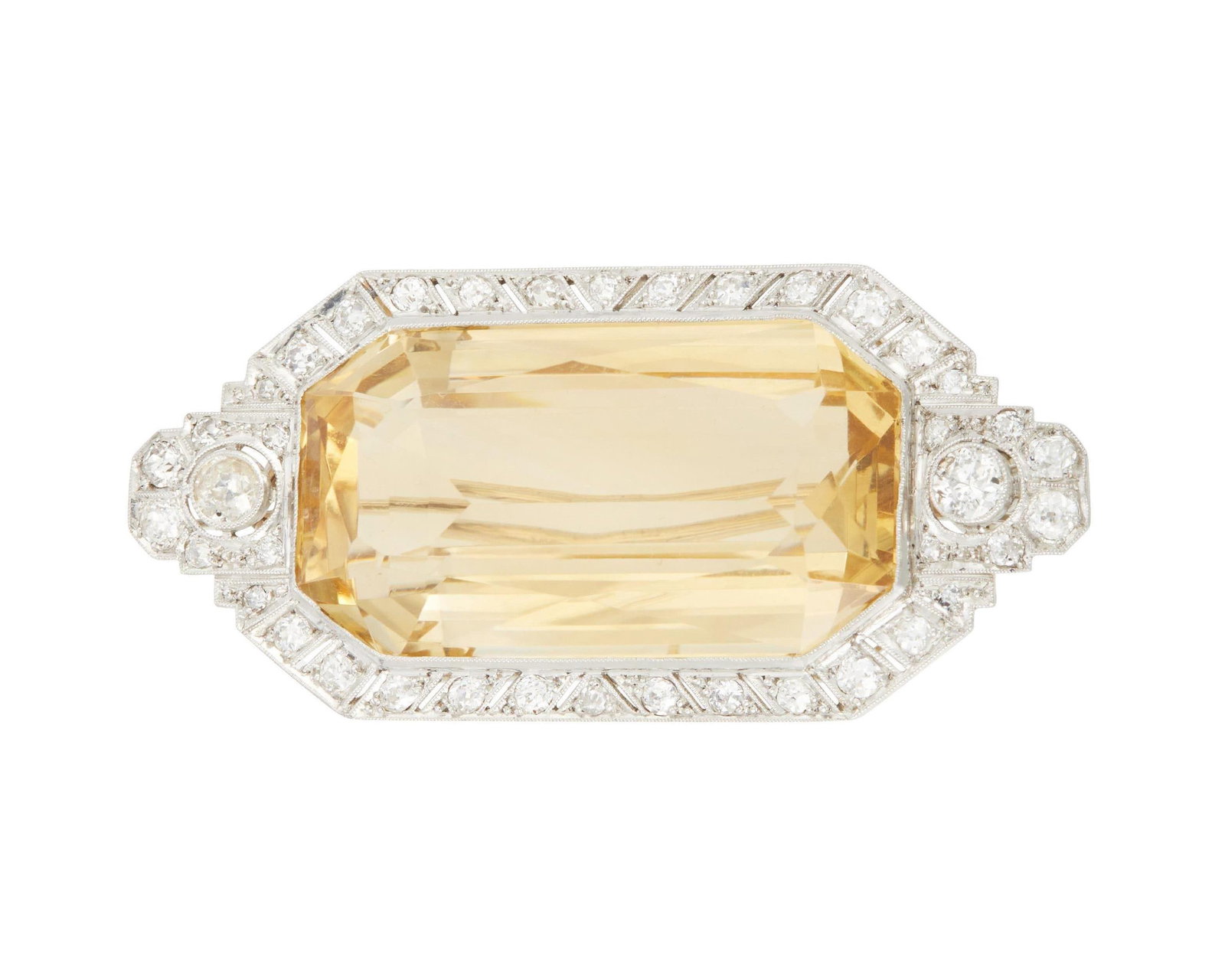 An Art Deco Citrine and Diamond Brooch: An Art Deco Citrine and Diamond Brooch Centering rectangular-cut citrine quartz measuring approximately 37mm x 19mm x 13mm and weighing approximately 60 carats, further accented by 40 old European-cut