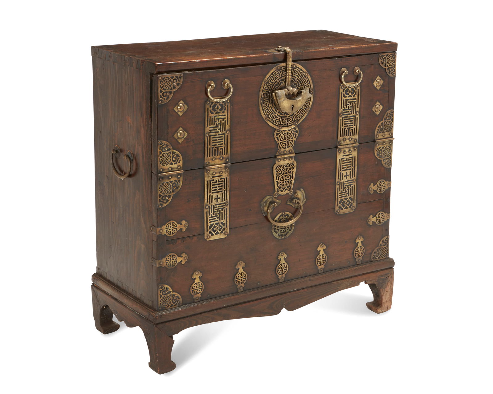 A Korean bandaji: A Korean bandaji20th centuryThe tall, dark wood blanket chest with drop-front top door, paper-lined interior, and fitted with reticulated brass hardware and opposed handles, raised on four bracket fee