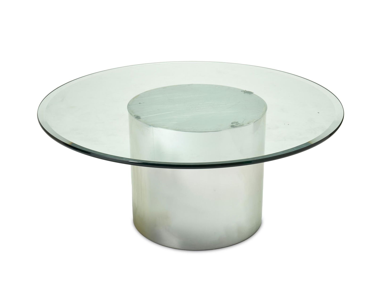 A Brueton-style polished chrome and glass cocktail table: A Brueton-style polished chrome and glass cocktail tableCirca 1980sThe contemporary table with a polished, cylindrical chrome base and a circular glass top20.5" H x 48" Dia.