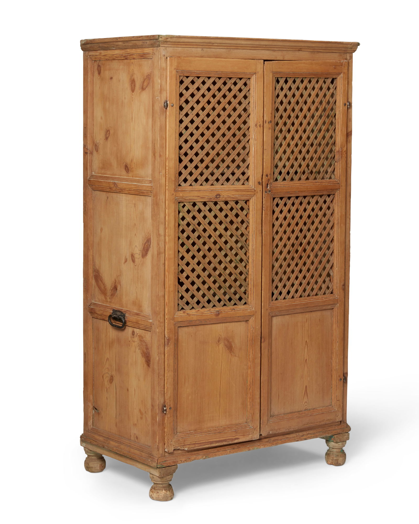 A Latin American wood cupboard: A Latin American wood cupboard19th/20th centuryThe wood cabinet with iron hardware and opposed handles to sides, two lattice-front hinged doors revealing three shelves of cut found wood, and four bun-
