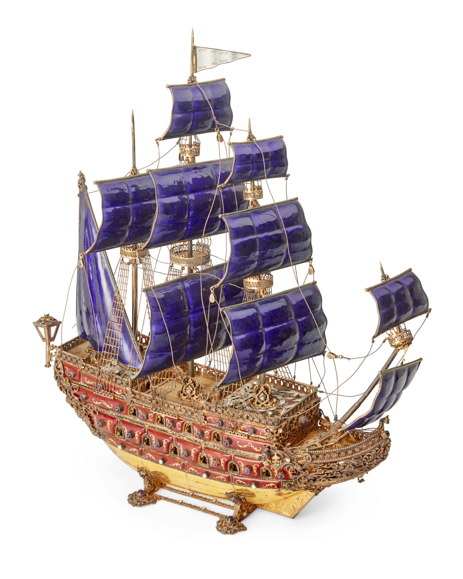 A Continental jeweled and enameled gilt metal galleon: A Continental jeweled and enameled gilt metal galleonLate 19th/early 20th centuryAppears unmarkedThe gilt metal man-o'-war with pierced and chased designs and siding, the gun ports set with amethyst a