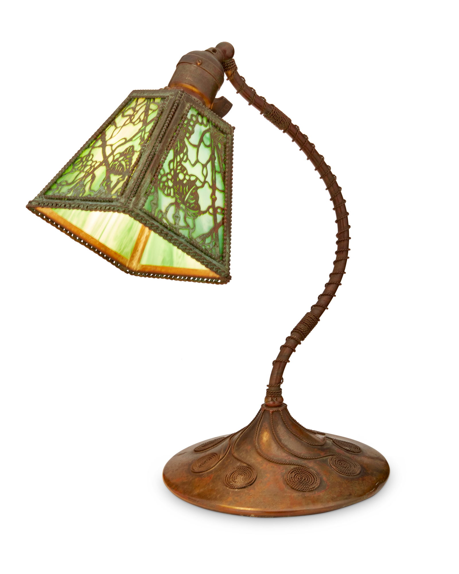 A desk lamp attributed to Riviere Studios: A desk lamp attributed to Riviere StudiosCirca 1915Appears unmarkedLikely a "Grapevine" desk lamp, the patinated metal single-light lamp with green slag glass shade under metal openwork in f