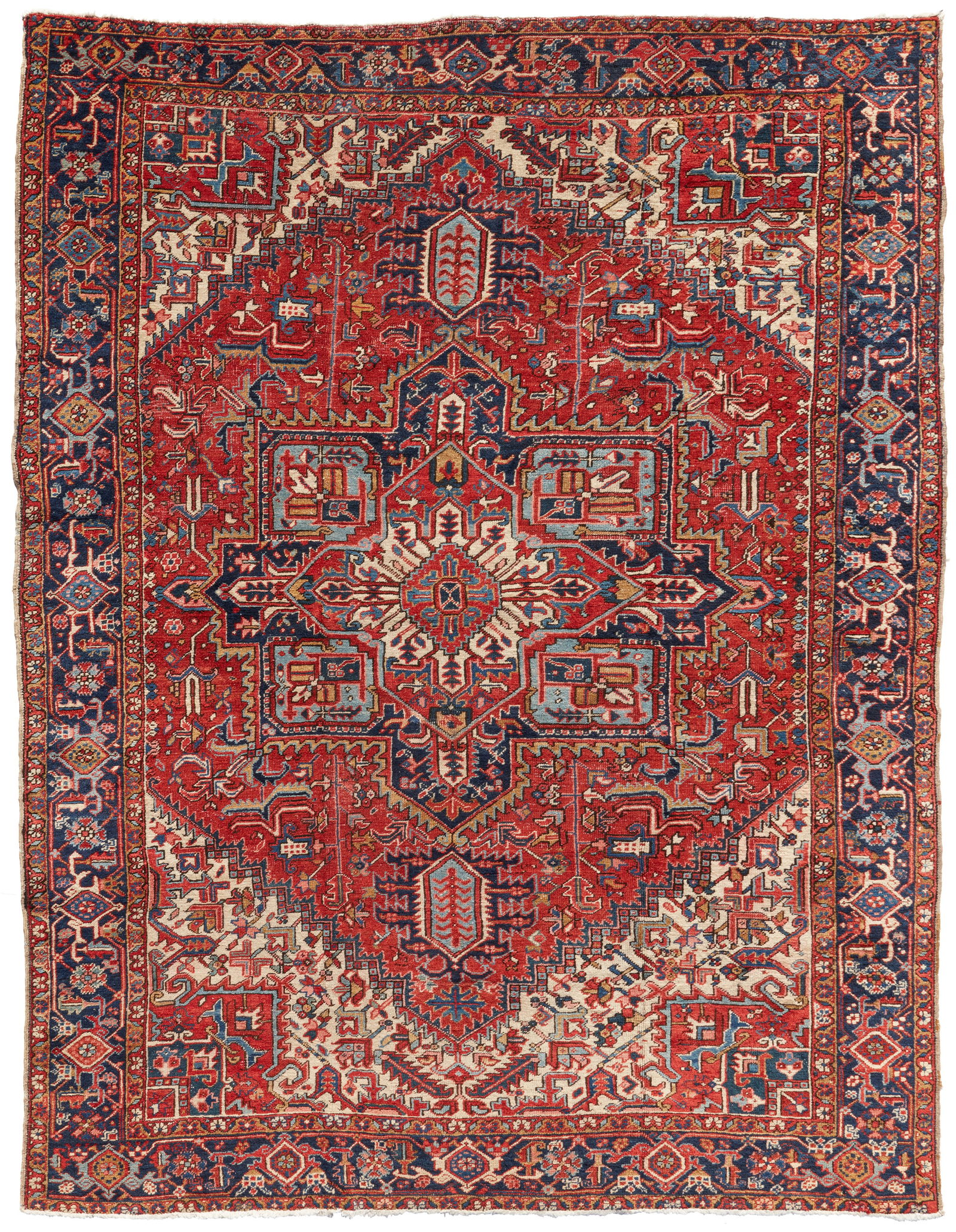 A Heriz rug: A Heriz rugEarly 20th century; IranWool on wool foundation, centering a four-pointed medallion surrounded by geometric foliate motifs in hues of dark blue, light blue, green, ochre, and cream on a rus