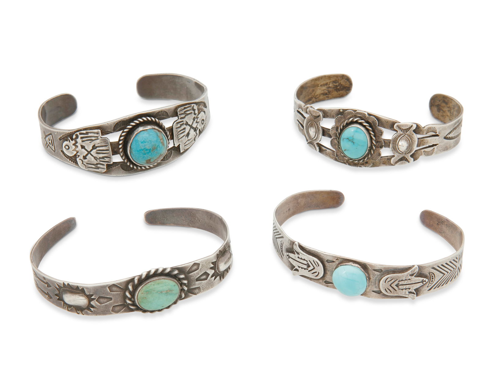 A group of Fred Harvey silver and turquoise cuff bracelets: A group of Fred Harvey silver and turquoise cuff braceletsEarly/mid-20th centuryOne marked for sterling; one marked: Silver / MexicoFour narrow ornate silver and set turquoise and blue stone cuffs, al