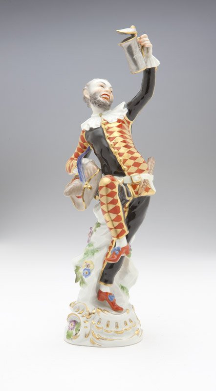A Meissen figure, Harlequin after JJ Kaendler: Mid twentieth century, underglaze blue cross swords mark and impressed model number 3025 to base, further marked to tankard 'ZM / 1738' with crossed swords, polychrome-glazed and gilt porcelain, after