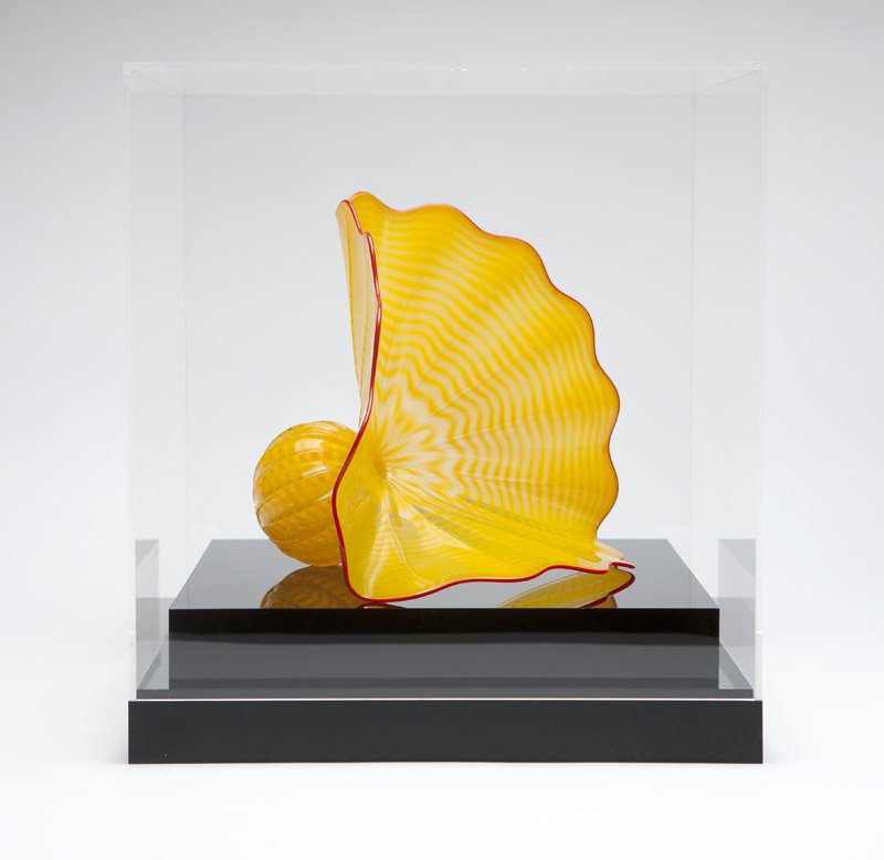 A Dale Chihuly / Portland Press 'Persian': 1996, signed ''Chihuly'' and ''pp96'', of buttercup yellow with red lip wrap, the wide undulating rim tapering to a tightly gathered neck over a spherical body, together with a Plexiglas vitrine, 8'' 