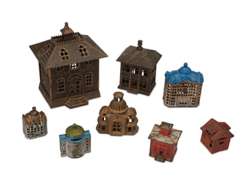 A group of cast iron still penny toy banks