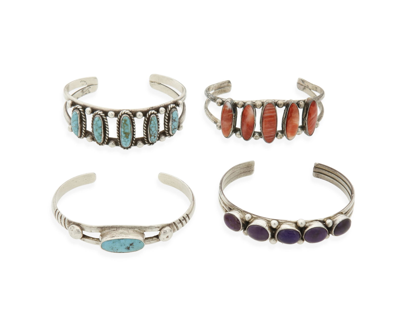A group of Southwest silver and stone set cuff bracelets: A group of Southwest silver and stone set cuff braceletsMid/late 20th centuryTwo marked: SterlingFour narrow silver cuffs with various single and row-set stones including turquoise, sugilite, and spin