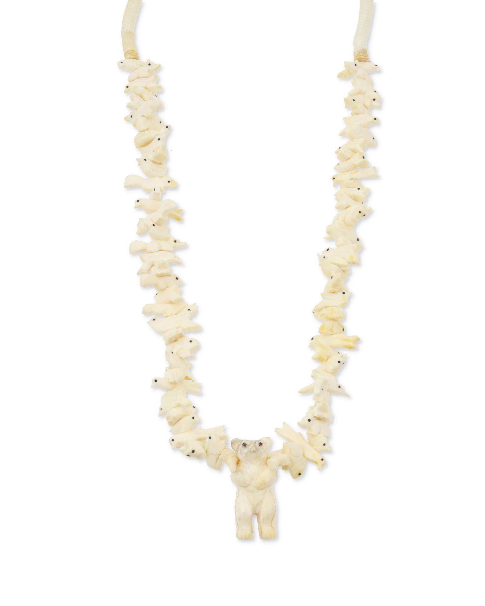 A Zuni Pueblo-style carved bone fetish necklace: A Zuni Pueblo-style carved bone fetish necklaceLate 20th centuryA chunky necklace with a central standing bear flanked by stacked carved bone animals including birds, turtles, squirrels, bison, rabbit