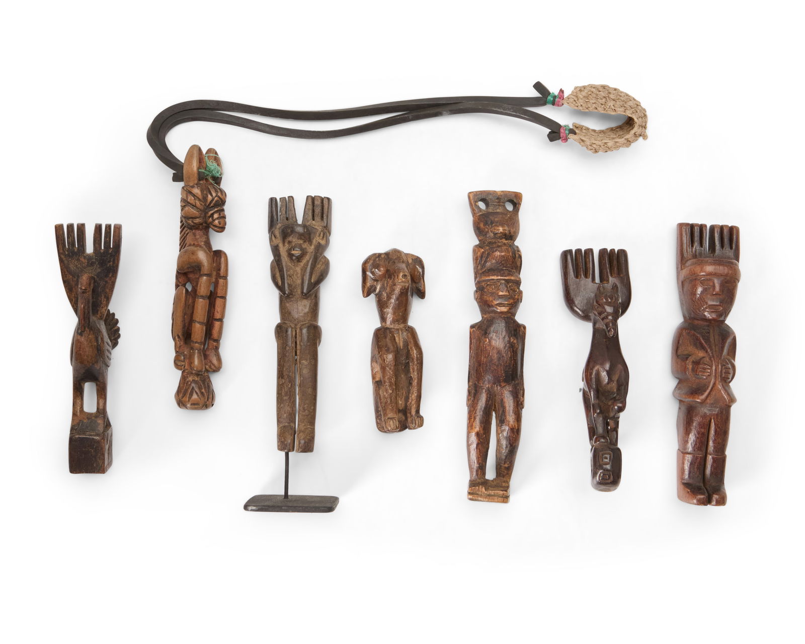 A group of Guatemalan slingshots: A group of Guatemalan slingshotsEarly 20th centuryThe carved wood figures, one raised on an enameled metal stand, comprising a pregnant female figure, a figure surmounted by a water jar, a horse figur