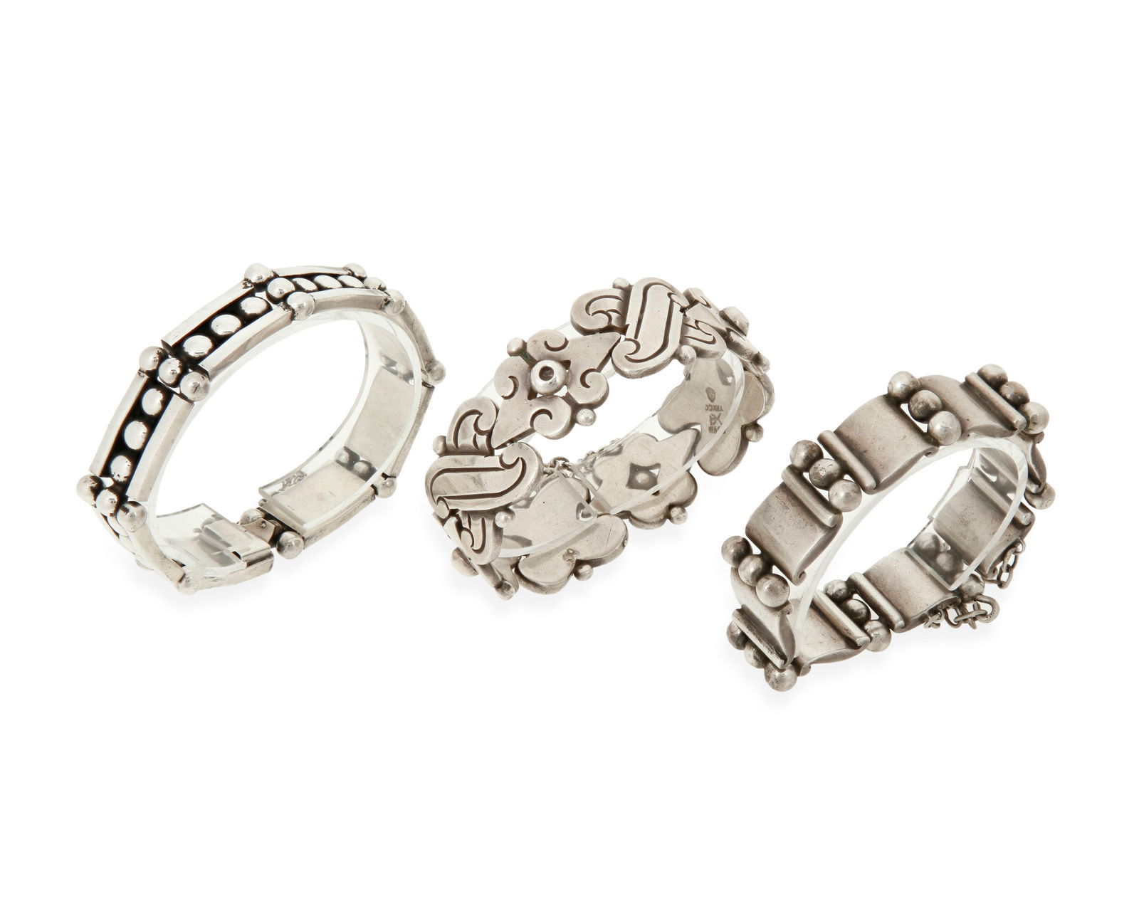 Three Hector Aguilar Mexican silver link bracelets: Three Hector Aguilar Mexican silver link braceletsHector Aguilar (1905-1986)Circa 1940-1945, 1948-1962; Taxco, MexicoEach variously stamped: HA [conjoined] / 940 / Taxco / [Eagle 9]Comprising a chunky