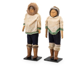 A pair of Inuit carved wood dolls