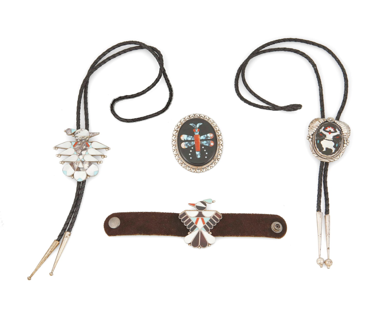 A group of Southwest Zuni-style stone and shell inlay jewelry: A group of Southwest Zuni-style stone and shell inlay jewelryMid/late 20th centuryVariously marked for makerFour works in silver comprising a turquoise, coral, and shell inlay Thunderbird "concho