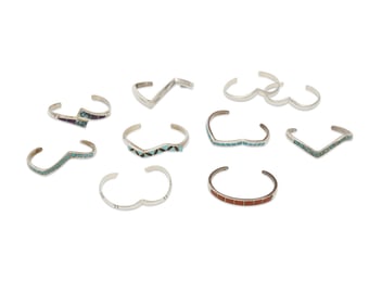 A group of Southwest-style silver and set stone cuff bracelets