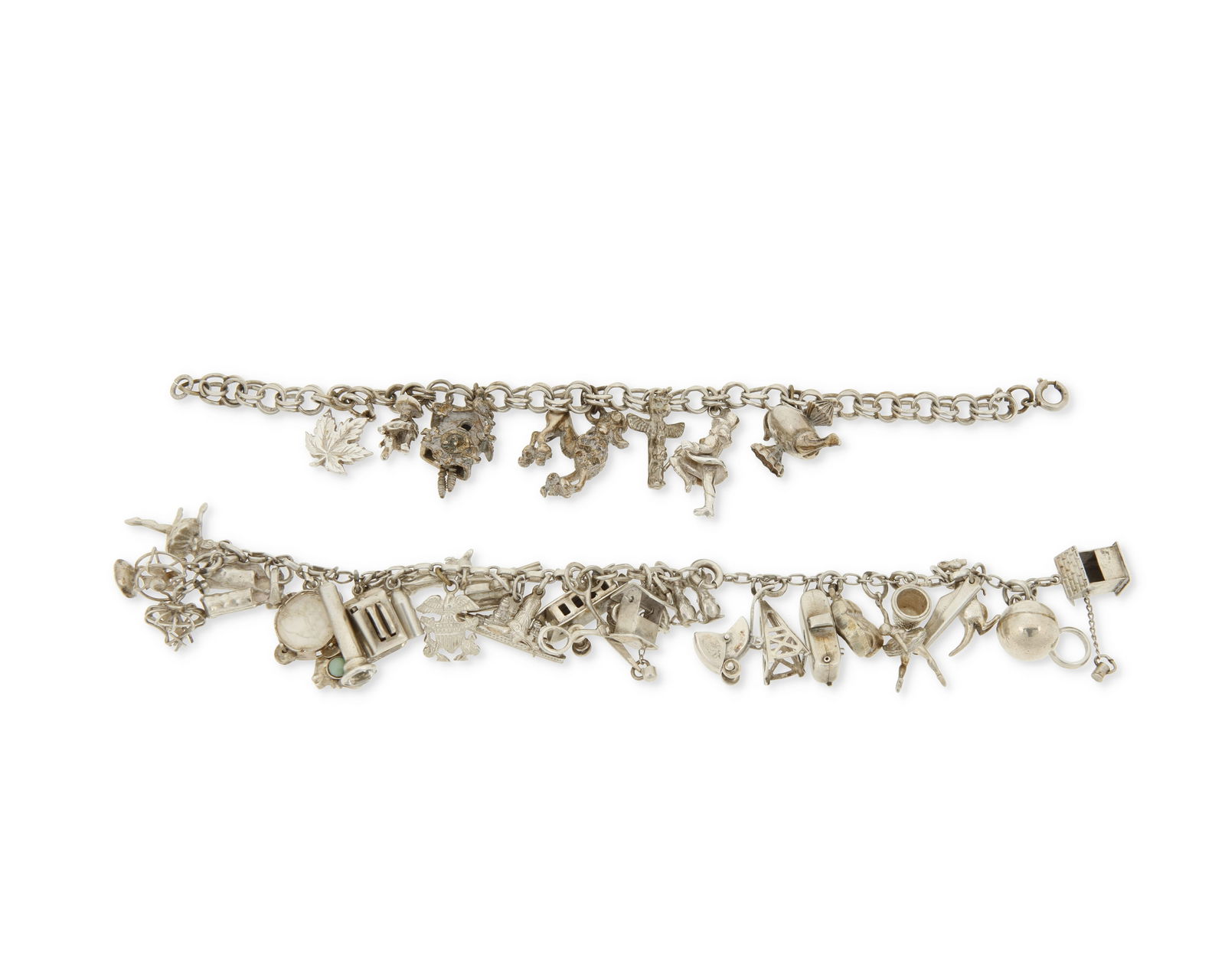 Two Silver Charm Bracelets: Two Silver Charm BraceletsOne featuring twenty-nine charms and the other seven charms, including a toaster, a totem pole, a camera and a pair of chapsLengths: 7 in. and 7 in.79.0 grams gross
