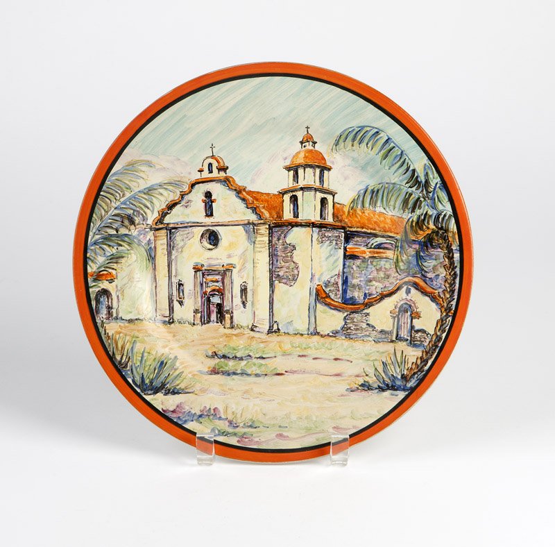 A Catalina red clay scenic plate, Florence Graham: Circa 1927 - 1931, impressed mark verso ''Catalina'', further marked in black ink ''F.M. Graham'' (Florence M. Graham), ''San Luis Rey Mission'', and ''369 - 65c'', of red clay polychrome-decorated wi