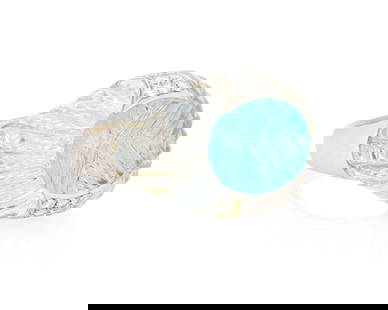 A White Gold, Blue Topaz and Rock Crystal Quartz Ring: A White Gold, Blue Topaz and Rock Crystal Quartz Ring Centering an oval mixed-cut blue topaz measuring approximately 16.48 x 12.78 mm, flanked by two carved rock crystal quartz elements and finished