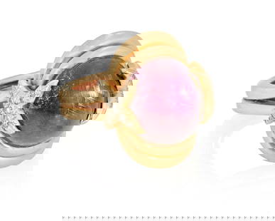 A Gold and Star Ruby Ring: A Gold and Star Ruby Ring Centering an oval ruby double cabochon measuring approximately 14.71 x 12.60 x 9.87mm, accented by "X" motifs set with round diamonds Size: 8 3/4 (with sizing