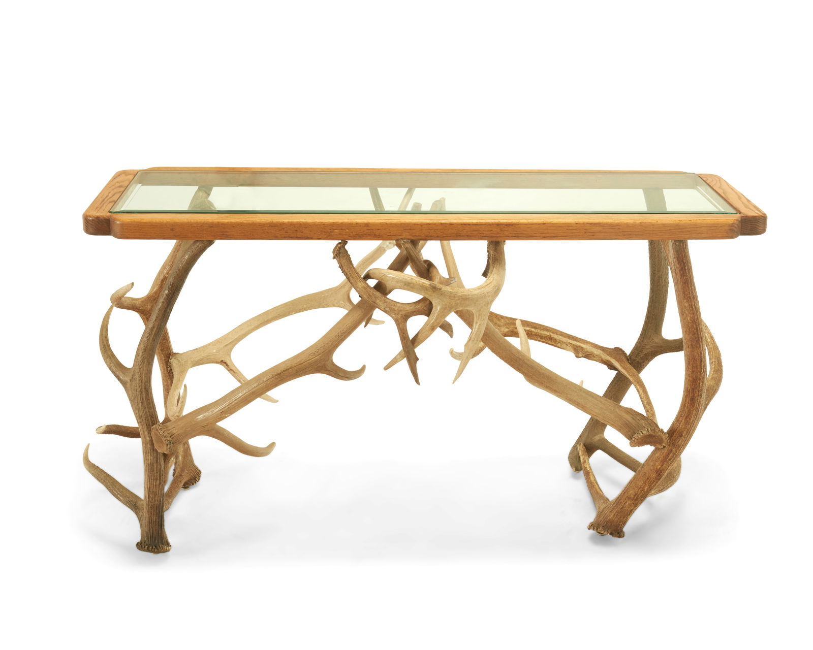 A stag antler console table: A stag antler console tableLate 20th centuryThe table with deer horn-support construction below a beveled glass top set in a wood frame31.5" H x 62.5" W x 25" D