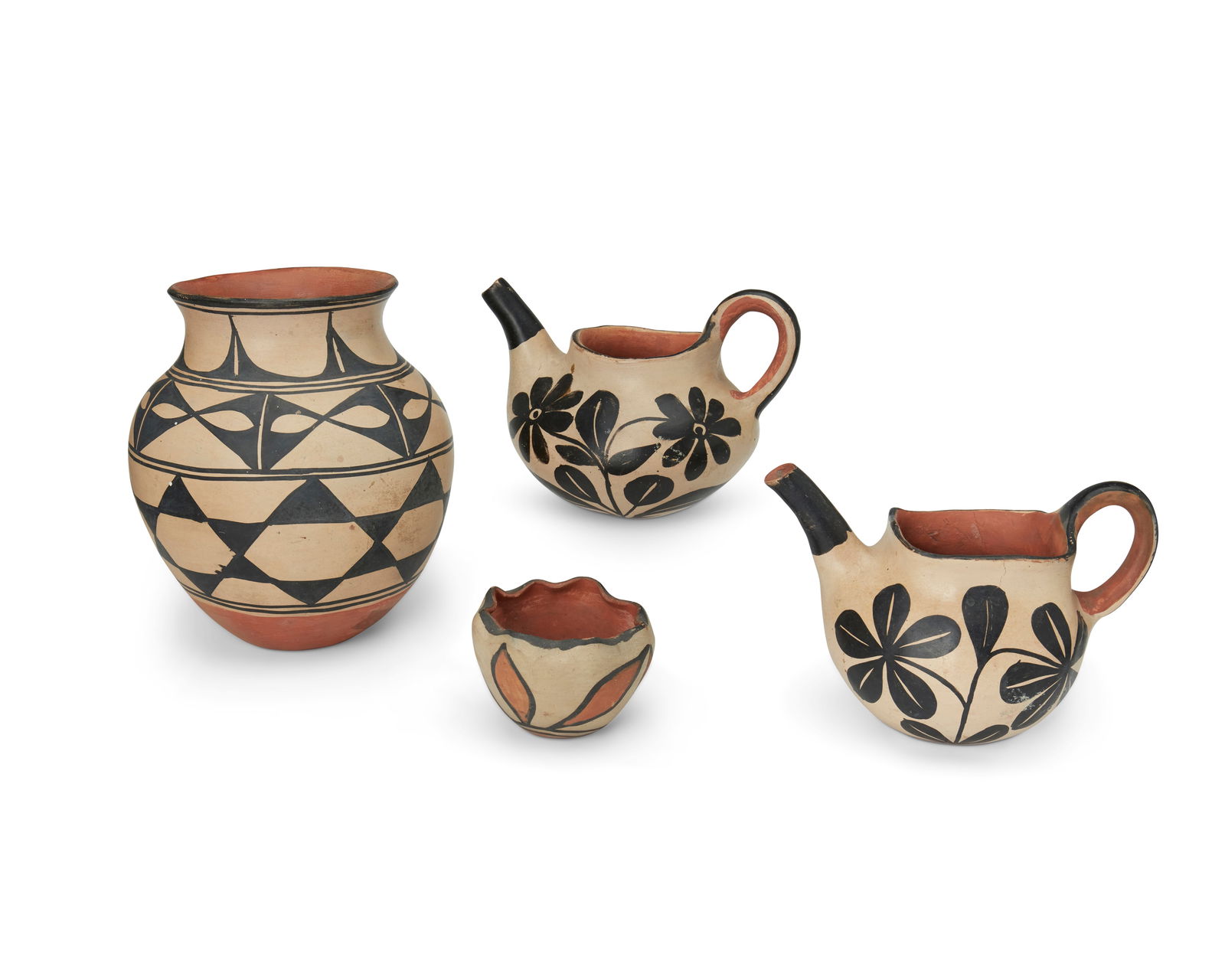 A group of Santo Domingo Pueblo polychrome pottery vessels: A group of Santo Domingo Pueblo polychrome pottery vesselsEarly/mid-20th centuryEach with black on white slip decoration above a terra cotta wash, comprising a tea pot and coffee pot with floral motif