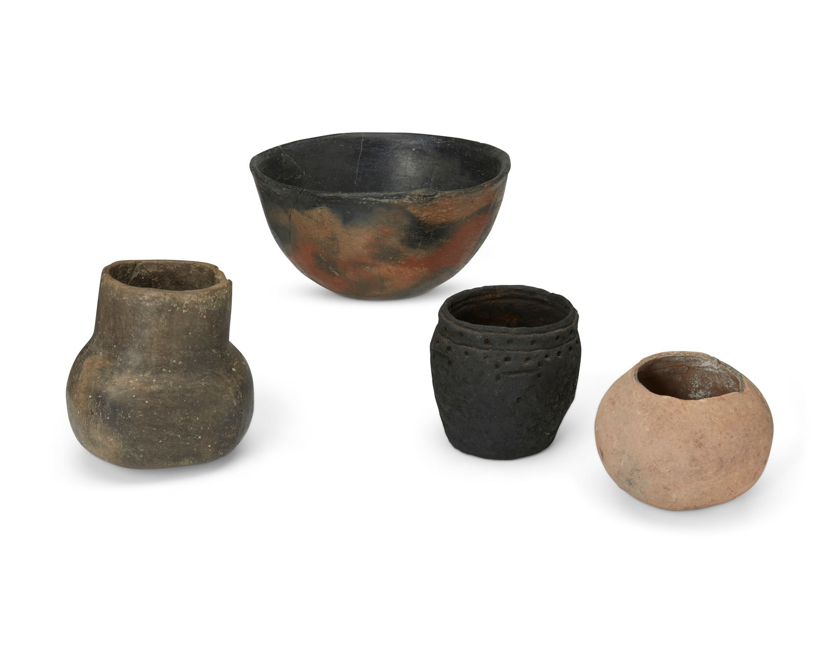 A group of Southwest pottery vessels: A group of Southwest pottery vesselsPrehistoric or laterComprising a cooking bowl, a fluted vessel, a jar with corrugated rim, and a rounded vessel4 piecesBowl: 4" H x 7.5" Dia.; Smallest: 3