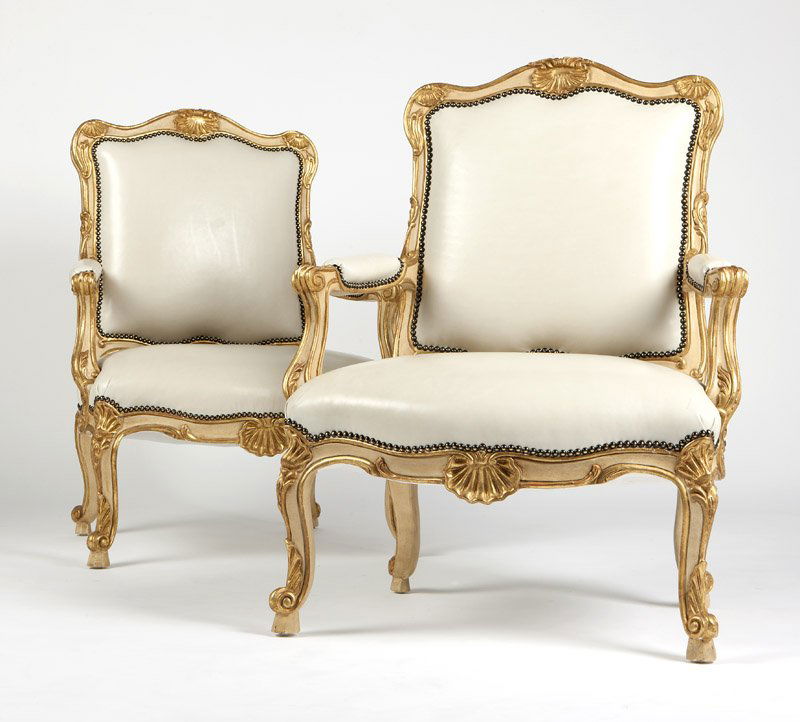 A pair of carved gilt wood armchairs: Contemporary, the padded seats and backs covered with smooth white leather, 2 pcs, each 41.75'' H x 32'' W x 28'' D, est:$800/1200 Provenance: Property from an Important Private Collection, Las Vegas,