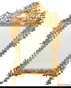 A Louis XV-style carved giltwood mirror: A Louis XV-style carved giltwood mirror19th centuryThe ornate frame with scroll and acanthus leaf motifs, with outer mirror border56.5" H x 39.5" W x 2.5" D Provenance:From the Collection of Robert A.