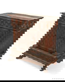 An Italian carved walnut credenza: An Italian carved walnut credenza18th centuryFitted with two drawers above a pair of locking cupboard doors opening to reveal a single shelf, flanked by fluted columnar and roundel accents to the corn