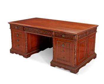 A Victorian-style carved mahogany pedestal desk