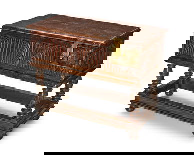 A William & Mary-style carved oak Bible box: A William & Mary-style carved oak Bible box20th centuryThe metal-mounted box with fan and rib carvings and a later lock on the right front edge, raised on a stand with four turned legs joined by stret