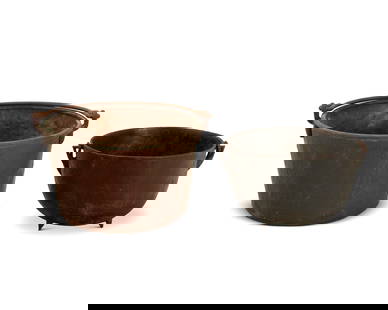 Two large handled cauldrons: Two large handled cauldrons19th centuryComprising one iron and one copper, each with a bail handle2 piecesIron: 15" H x 27" Dia.; Copper: 18" H x 32" Dia. Provenance:From the Collection of Robert A. D