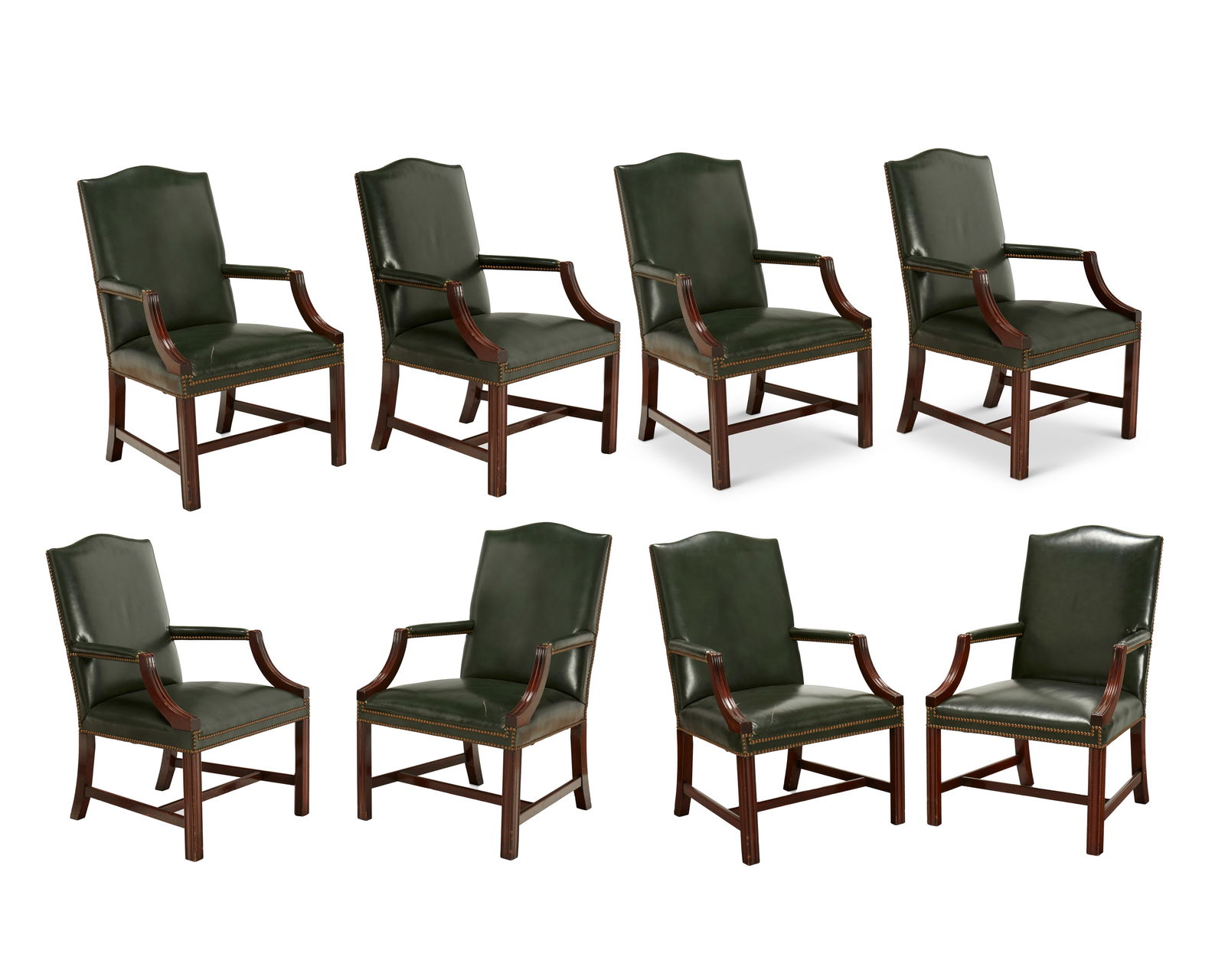 A set of eight Kindel George III-style mahogany armchairs: A set of eight Kindel George III-style mahogany armchairsLate 20th centuryMost with Kindel paper label to undersideEach carved wood chair upholstered in a green leather with brass tacking8 piecesEach: