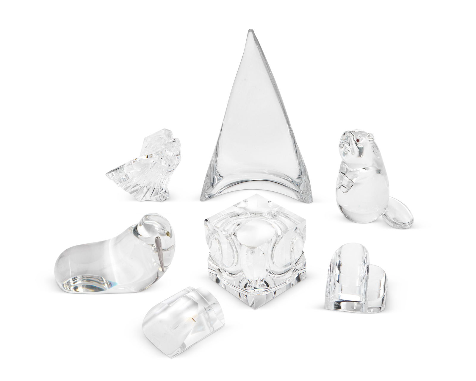 A group of Steuben glass table decorations: A group of Steuben glass table decorationsLate 20th/early 21st centuryMost marked for SteubenComprising a sculpted glass cube 'Passage' paperweight designed by Peter Aldridge (4" H x 4" W x 4" D), an