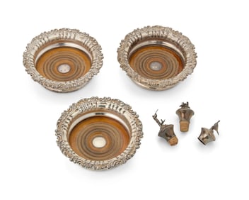 A set of three English sterling silver wine coasters and stoppers