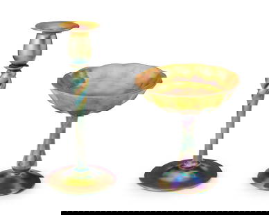 A Steuben Aurene glass compote and candlestick: A Steuben Aurene glass compote and candlestick1920sEach etched to underside: Steuben / Aurene; candlestick further etched: 686The iridescent gold glass items, comprising a footed compote and a footed