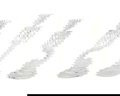 Three Baccarat glass figural candlesticks: Three Baccarat glass figural candlesticksLate 20th centuryEach with Baccarat stenciled factory marksComprising a pair with dolphin-form standards and a single with putto-form standard, each faceted wi