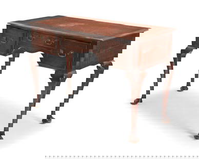 A George II provincial-style oak writing desk: A George II provincial-style oak writing desk19th centuryThe wood desk with molded edges above three drawers with joinery and brass bulls, raised on cabriole legs with pad feet31" H x 45" W x 21" D