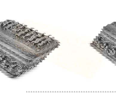A Burmese sterling silver box: A Burmese sterling silver box20th centuryUnmarkedThe slender, rectangular vessel with elaborate pierced scrolled motifs surrounding chased and repousse haute-relief figures4.25" H x 14.25" W x 4.25" D