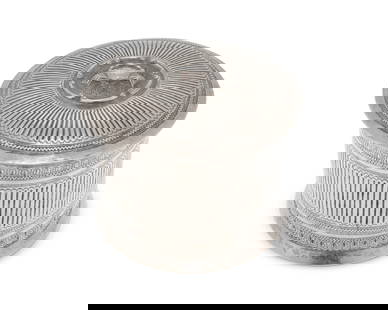 A Burmese sterling silver betel nut box: A Burmese sterling silver betel nut box20th centuryAppears unmarkedThe round vessel with chased and repousse reeded pattern, the lid with a haute-relief crab motif within a C-scroll medallion4.75" H x