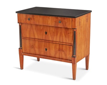 A Biedermeier part-ebonized cherry veneer commode