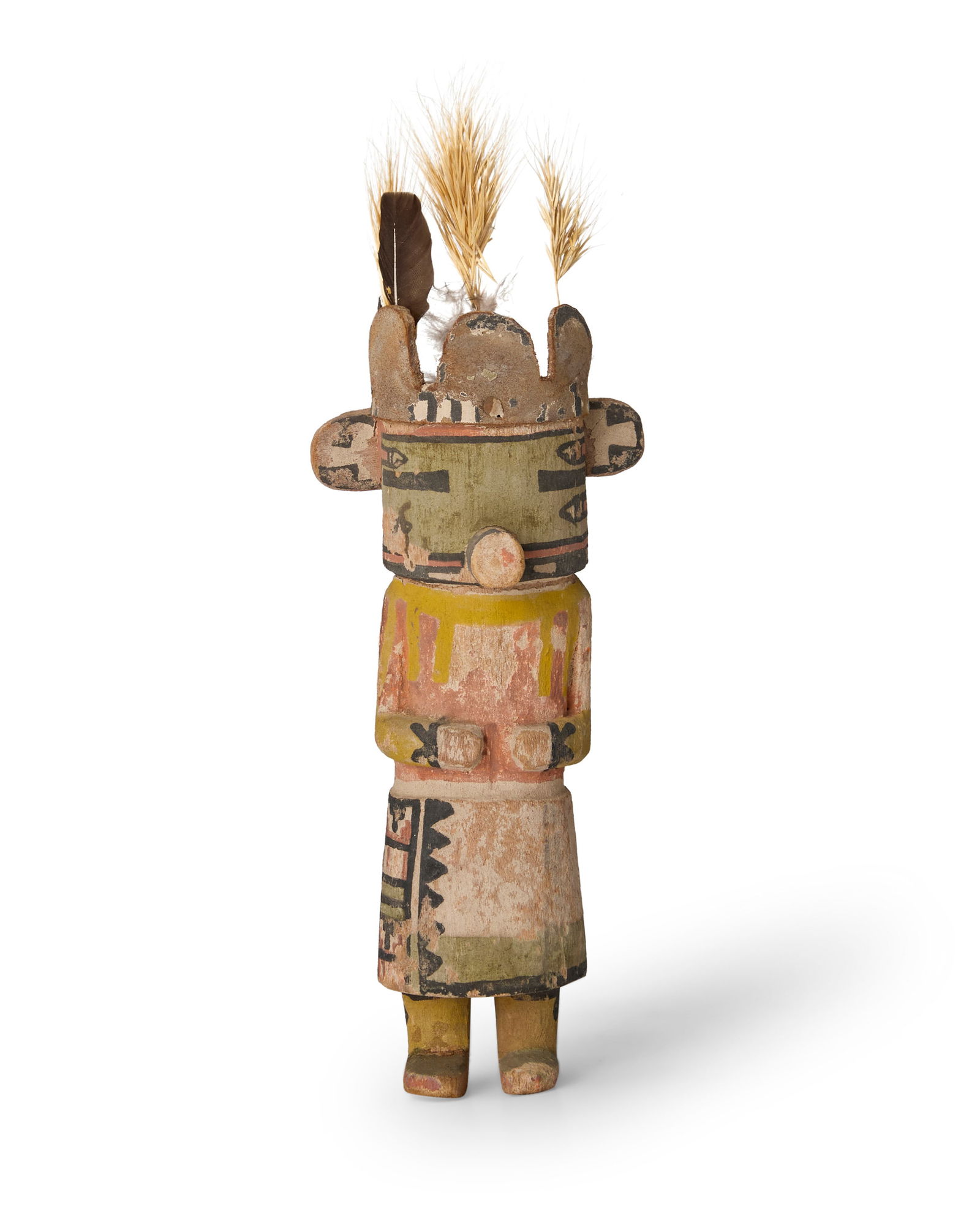 A Southwest Pueblo katsina figure: A Southwest Pueblo katsina figureEarly 20th centuryUnmarkedThe carved and polychromed cottonwood masked figure with small leather tableta and mounted feathers and grass stalks9" H x 4" W x 2.75" D