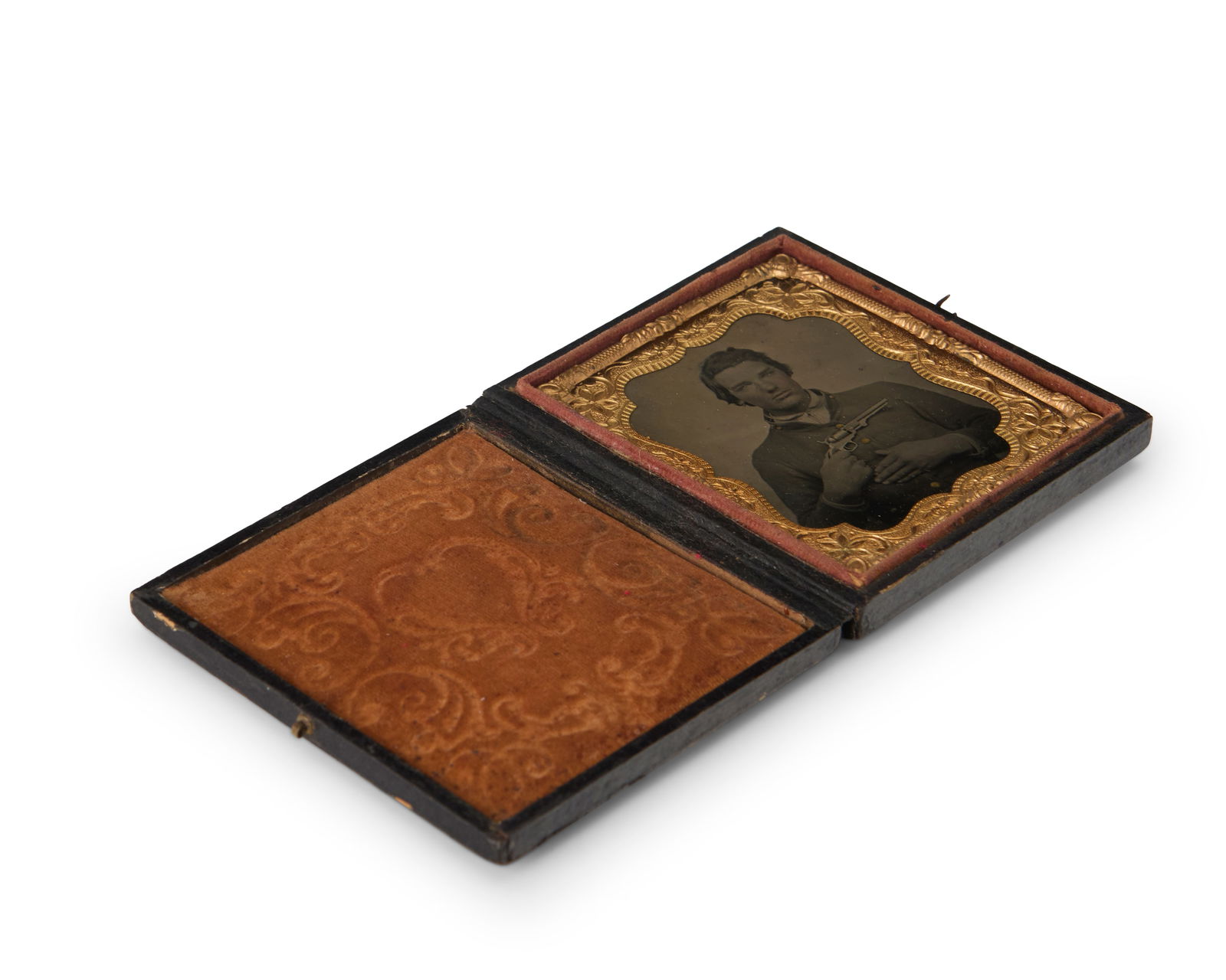 A Civil War era tintype: A Civil War era tintypeA tintype depicting a soldier holding his revolver, with a chased gold-toned metal preserver with a burnt orange velvet-lined tooled leather caseSight: 2.5" H x 2" W