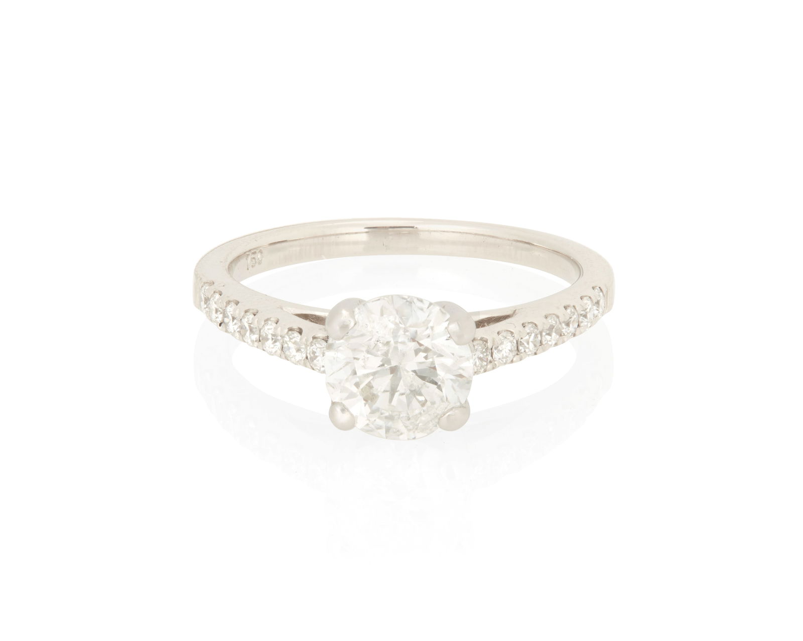 A 18K White Gold and Diamond Ring: A 18K White Gold and Diamond RingCentering a round diamond weighing approximately 1.15 carats, accented by round diamonds down half the shankSize: 5 1/23.3 grams gross