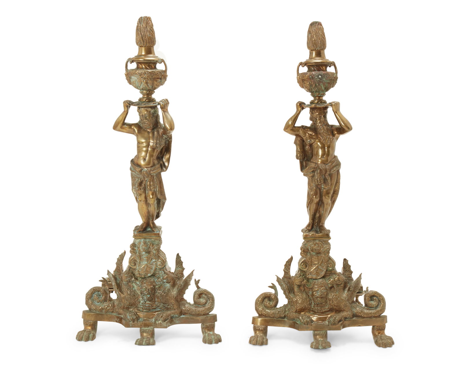 A pair of Renaissance-style brass figural andirons: A pair of Renaissance-style brass figural andironsLate 19th centuryEach depicting a partly robed figure of Hercules hoisting a flaming urn, raised on a shaped base featuring a pair of opposed dragons